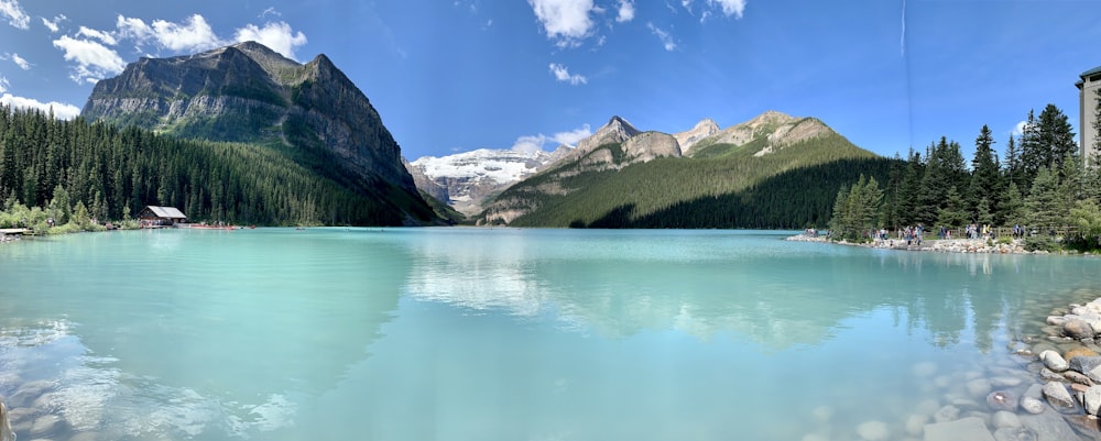 Un lago circondato da alberi e montagne sotto un cielo blu