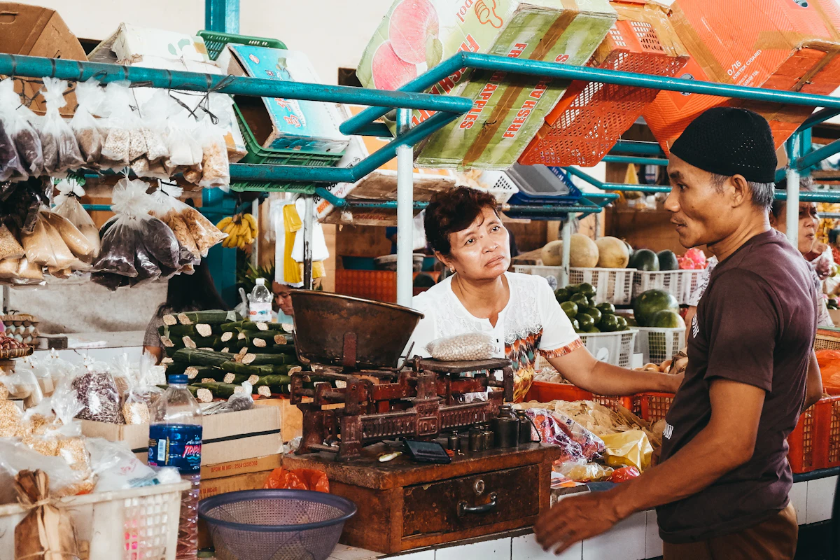 Penjual melayani pembeli di kios kecilnya