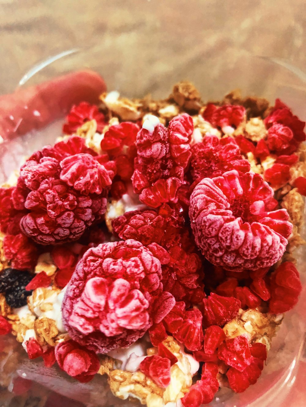 a close up of a bowl of cereal with raspberries