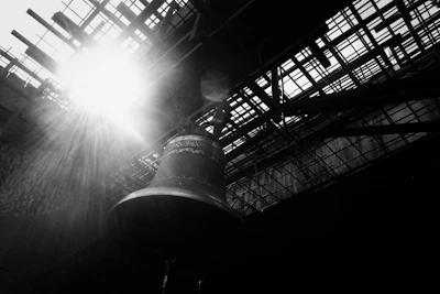 Golden temple bells hanging gracefully with soft sunlight filtering through.