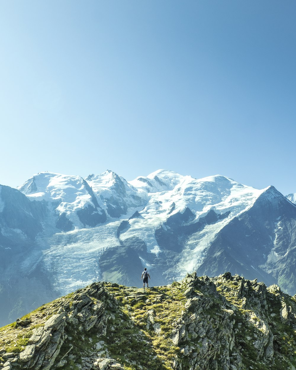 man standing overlooking mountain at daytime