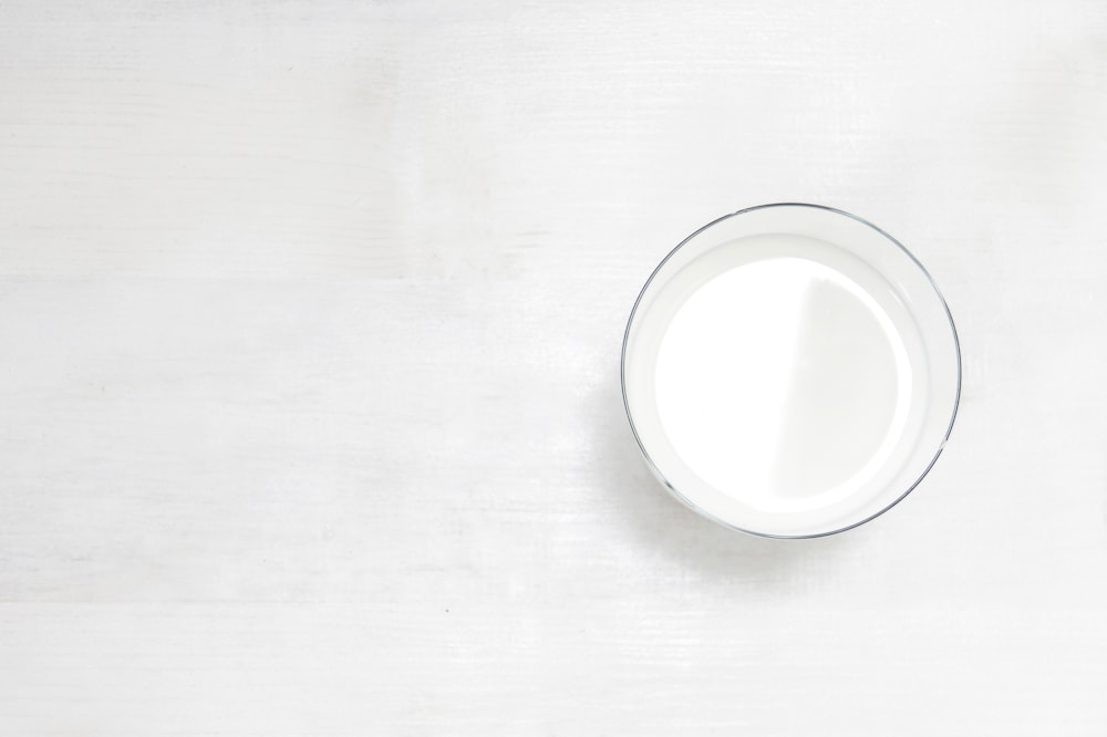 un verre de lait posé sur une table blanche