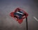 A red golf putter head with a modern shape, featuring the brand name TaylorMade and the model name Spider written on it. The putter has a glossy finish and is designed with a mix of sharp and smooth edges for improved performance.
