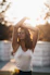a woman in a white tank top stretching her arms