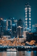 concrete buildings beside body of water during nighttime