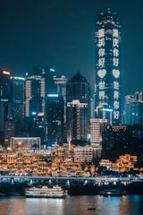 concrete buildings beside body of water during nighttime