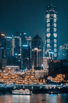 concrete buildings beside body of water during nighttime