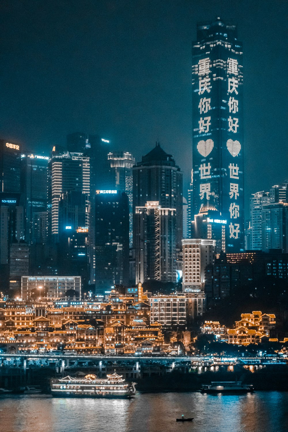 concrete buildings beside body of water during nighttime