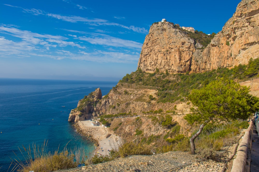 rock cliff beside ocean at daytime