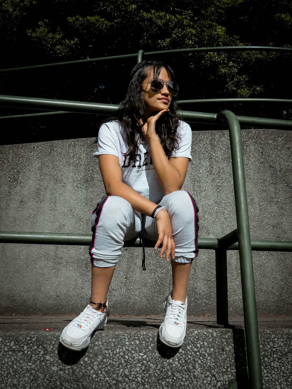 woman sitting on bar fence