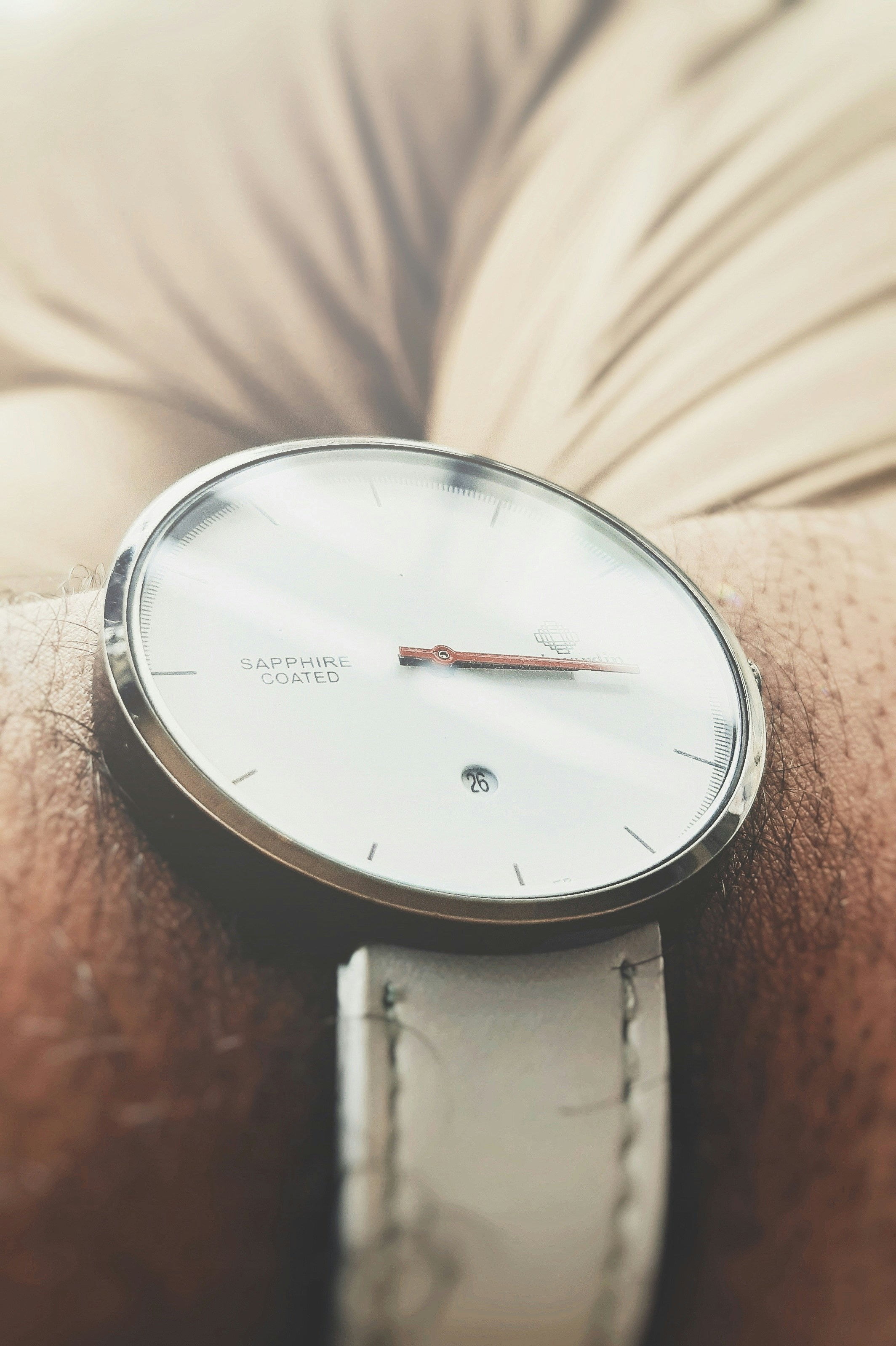 A close-up of a sleek, modern watch on a dark background.