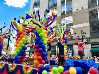 assorted-color balloons at daytime parade teams background