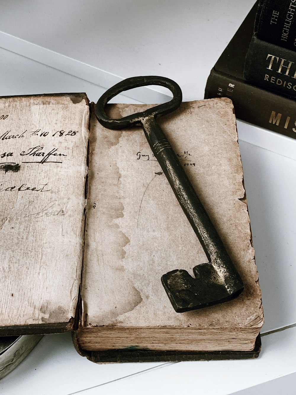 an old book with a key on top of it