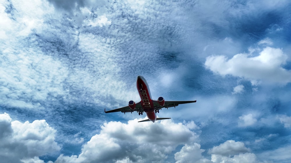 flying black and white airliner under white clouds