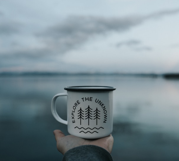 person holding white mug