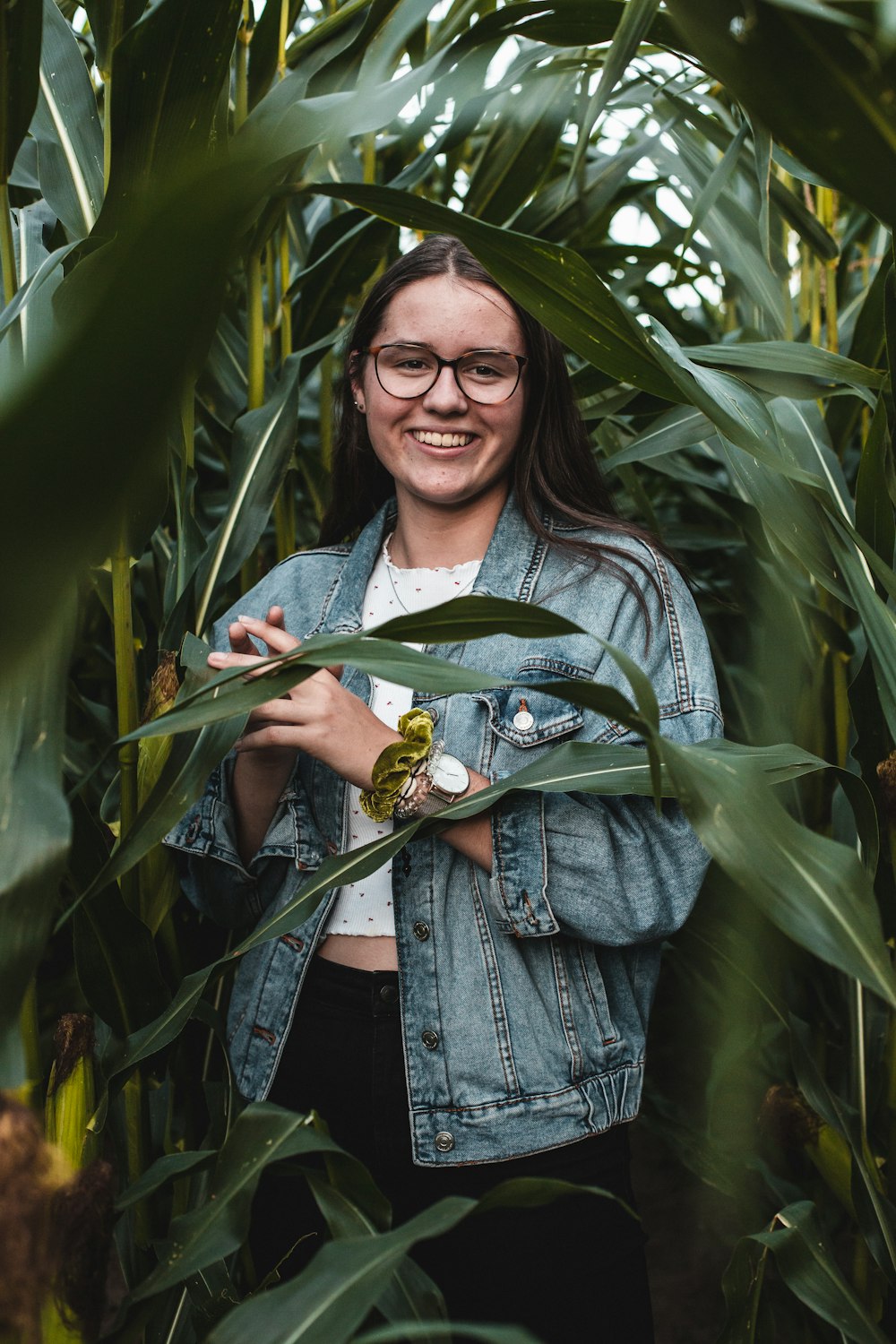 selective focus photo of woman standing near green plants