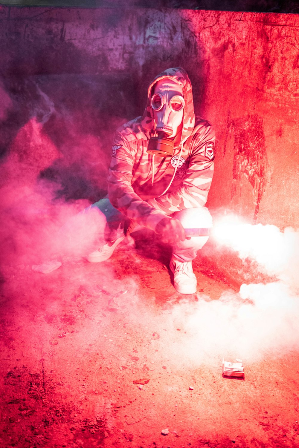 a man in a gas mask sitting on the ground