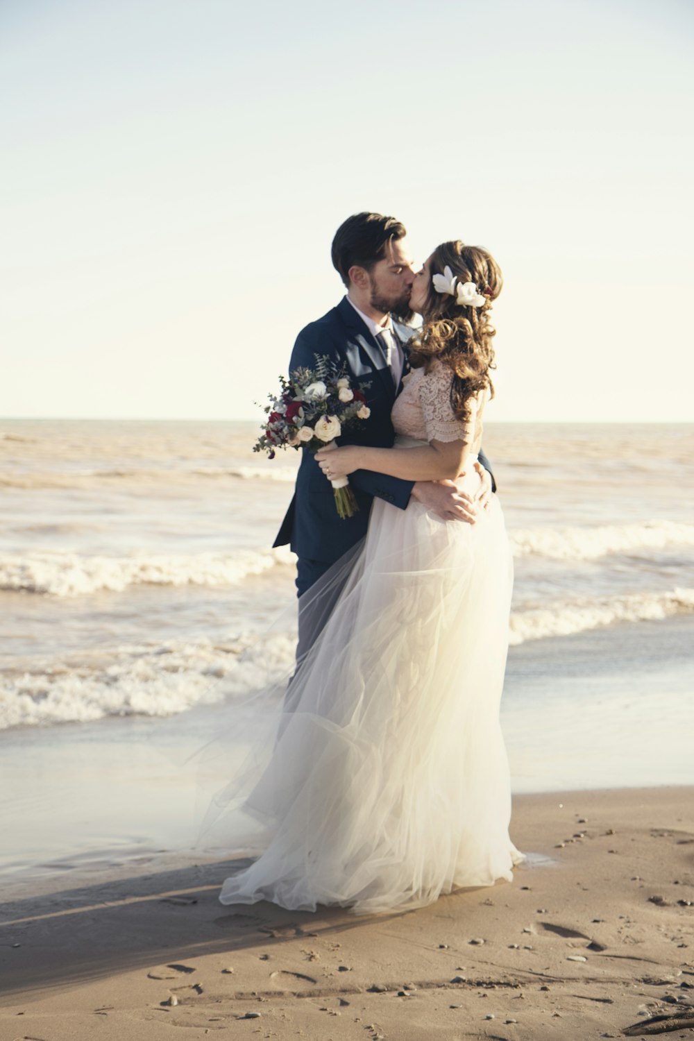 mariée et le marié debout à côté du rivage