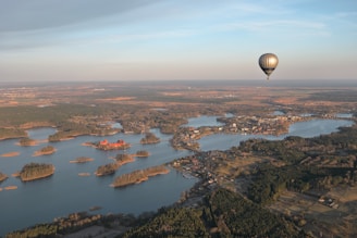 a hot air balloon flying over a large body of water