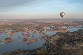 a hot air balloon flying over a large body of water