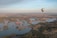 a hot air balloon flying over a large body of water