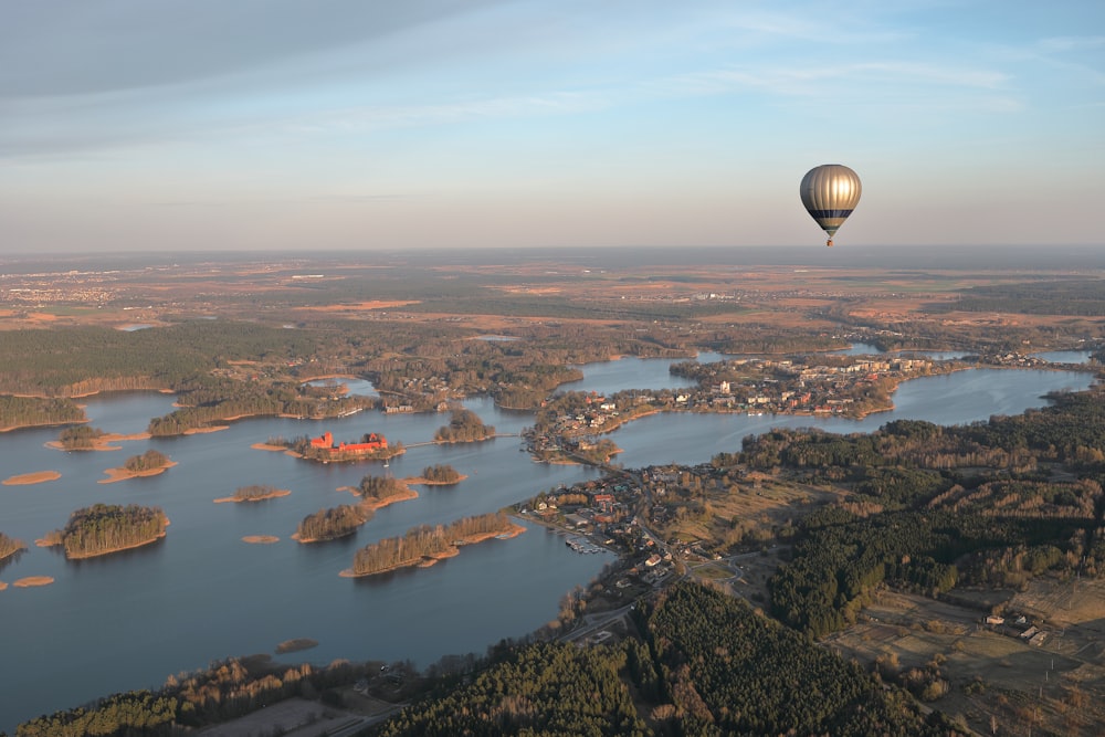 Ein Heißluftballon, der über ein großes Gewässer fliegt