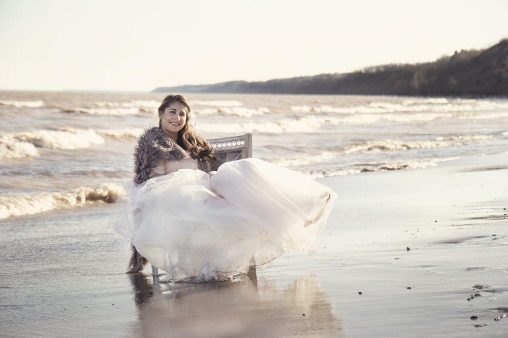 woman sitting on chair on seashore during day