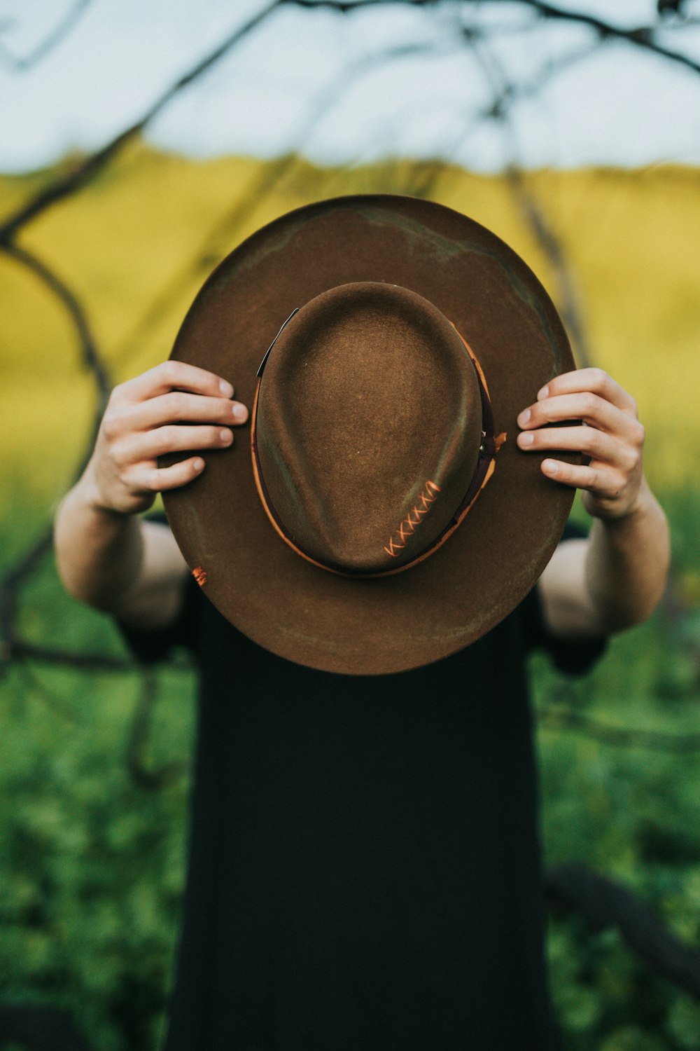 person holding brown hat