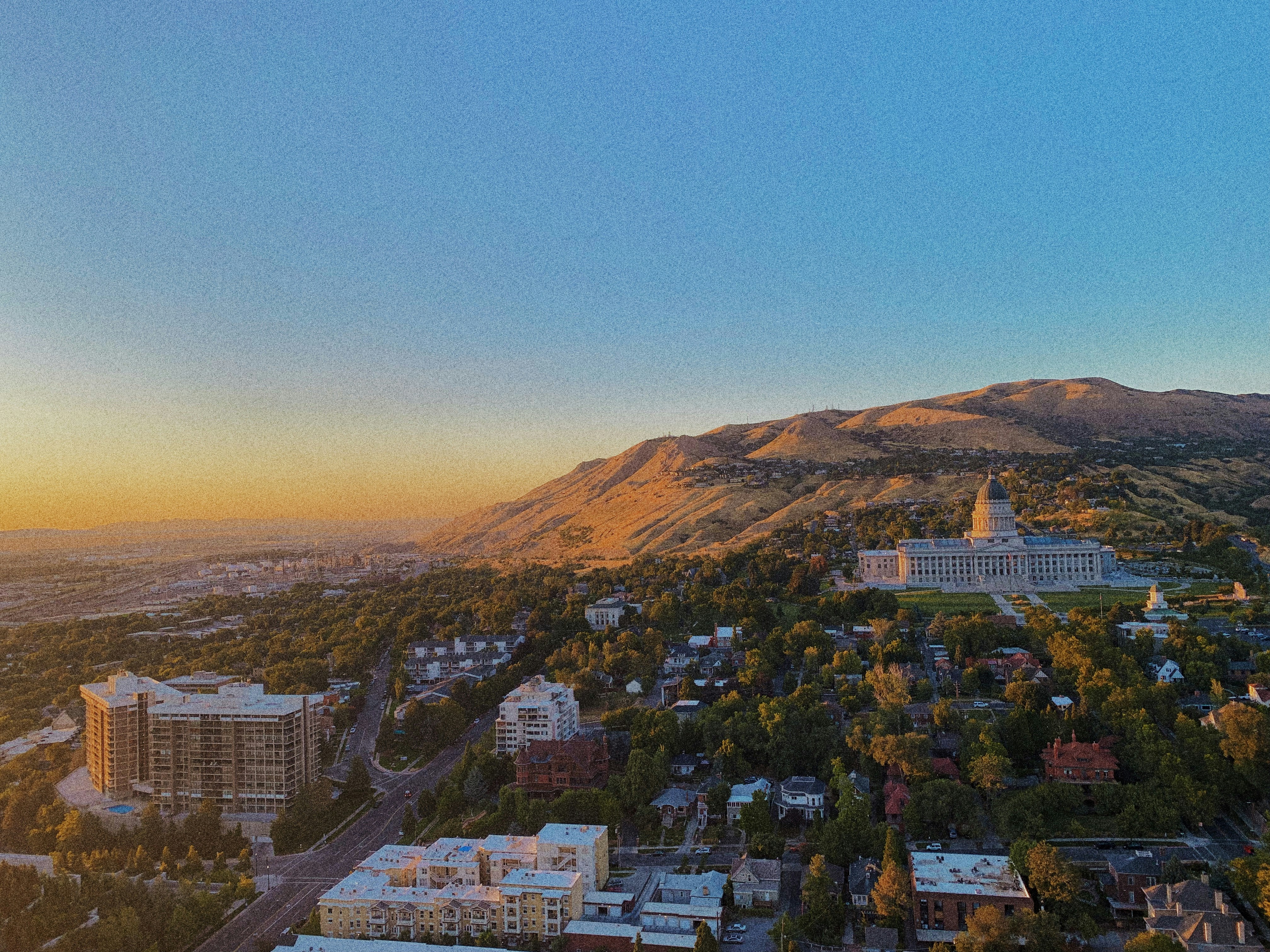 Minecraft landscape with mountains and buildings at golden hour