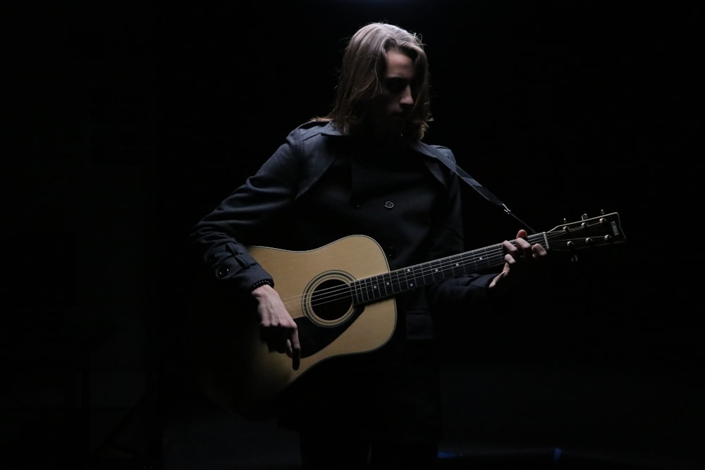 hombre tocando la guitarra acústica