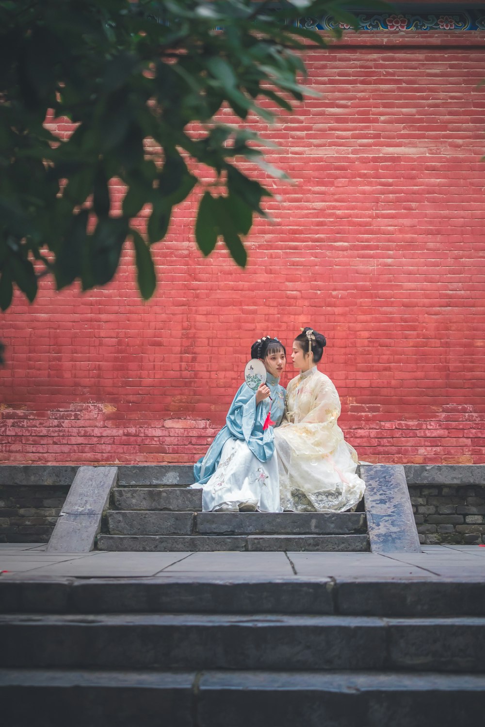 two women sitting on concrete stairs