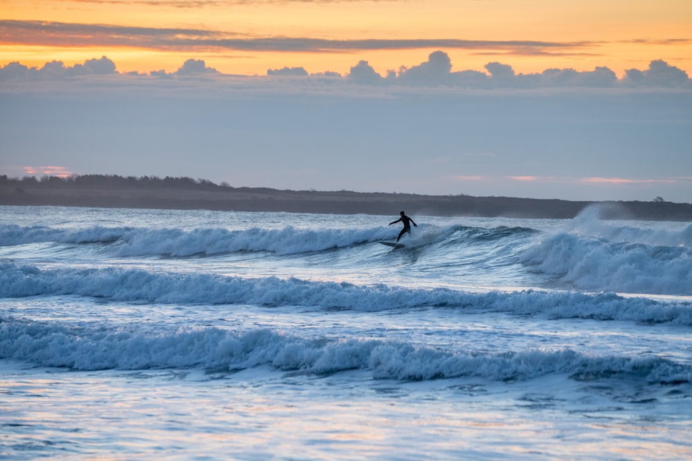 photography of person playing surfboarding during daytime