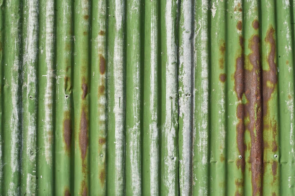 a close up of a green wall with rust