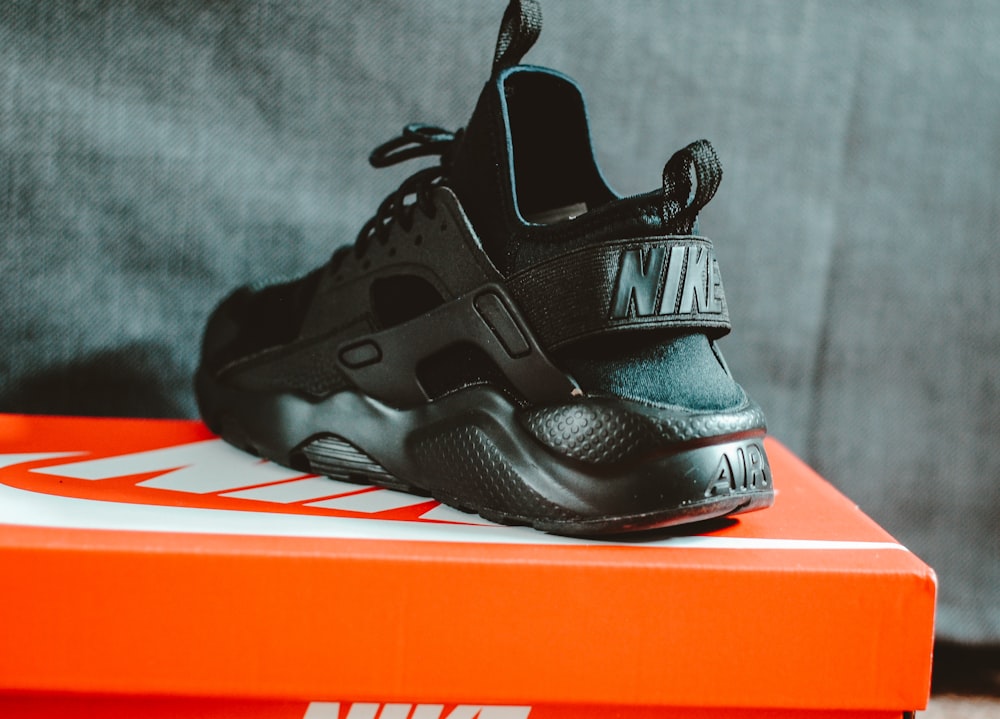 unpaired black Nike Huarache running shoe with box