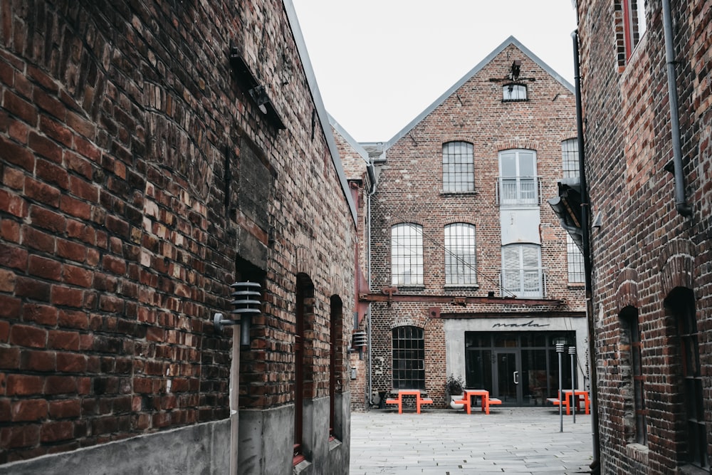 a narrow alley way with a brick building in the background