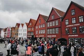 A bustling street scene in a northern town, with people going about their day under overcast skies.