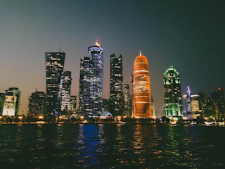 A sleek nighttime cityscape of Jakarta glowing with cyan and teal smart city overlays and digital data streams.