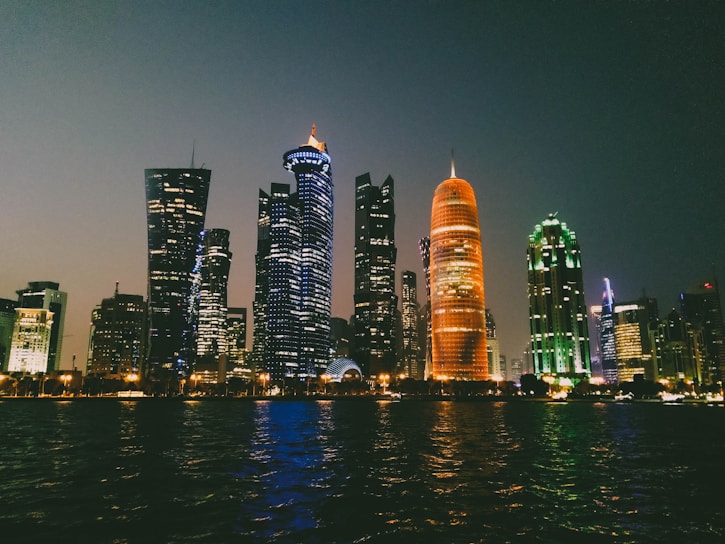 A sleek, dark-themed cityscape at night with glowing orange and cyan lights highlighting key neighborhoods.