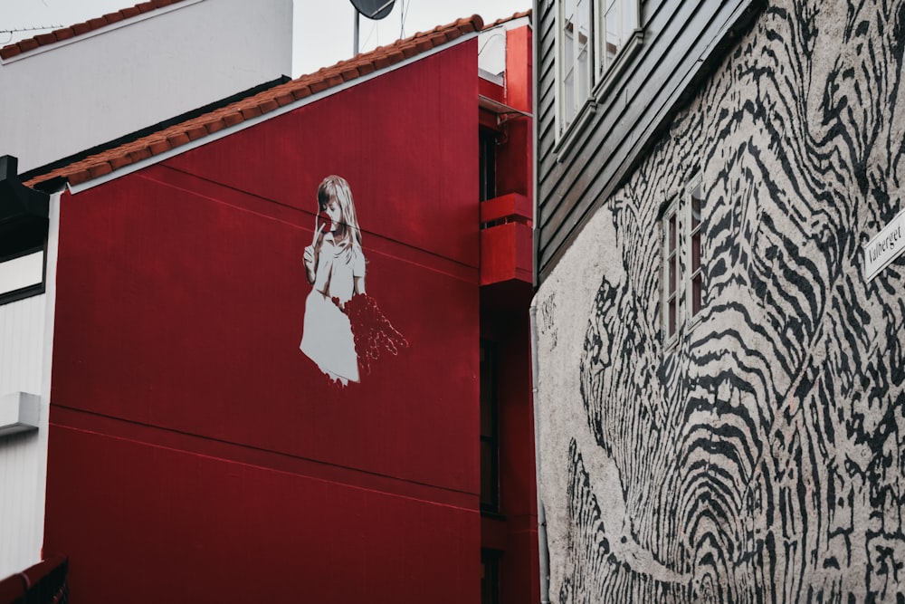 a red building with a painting of a woman on it