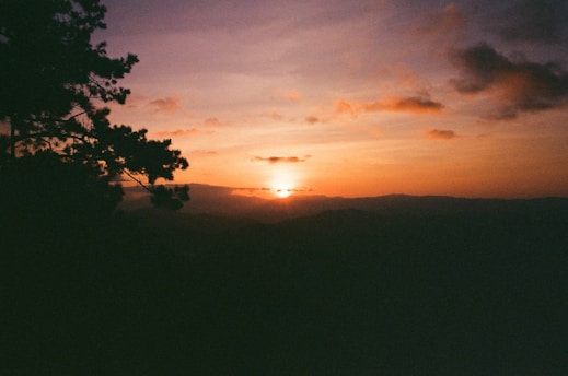 A scenic view of the Jujuy mountains at sunset, showcasing vibrant colors in the sky.