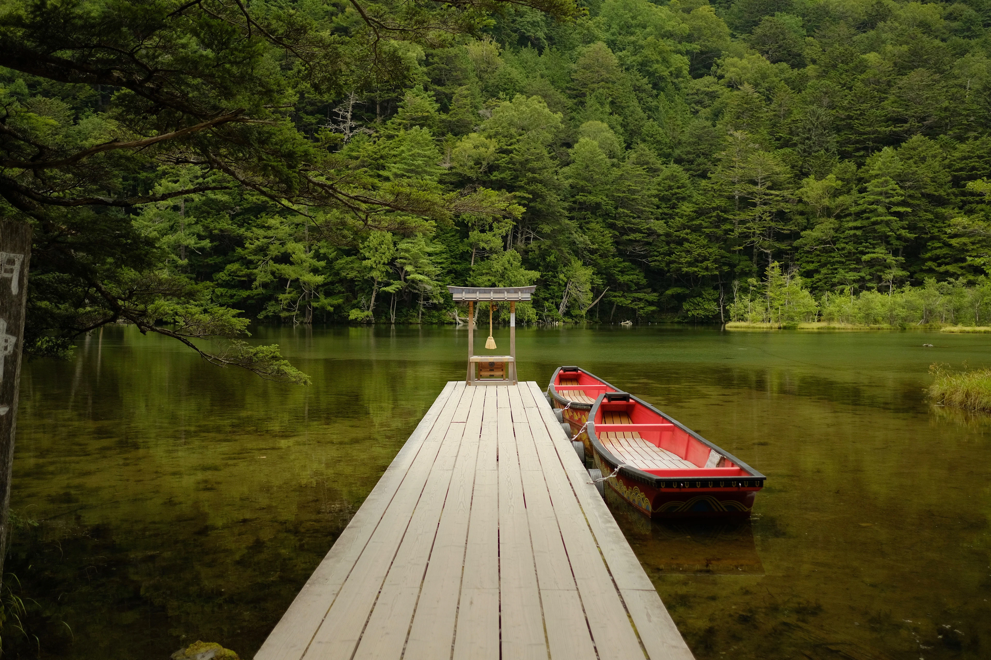 A wooden jetty and boat on Myojin Pond in Kamikochi