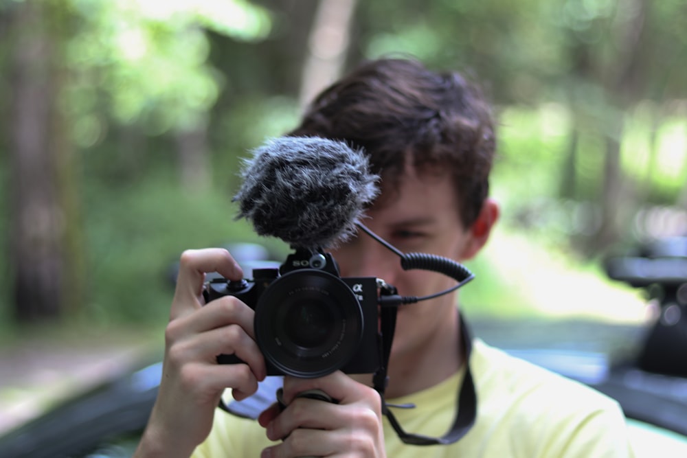 man holding black DSLR camera close-up photography