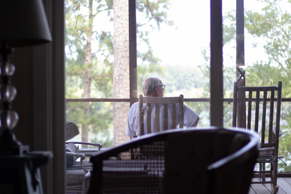 man sitting on chair near empty chair indoors