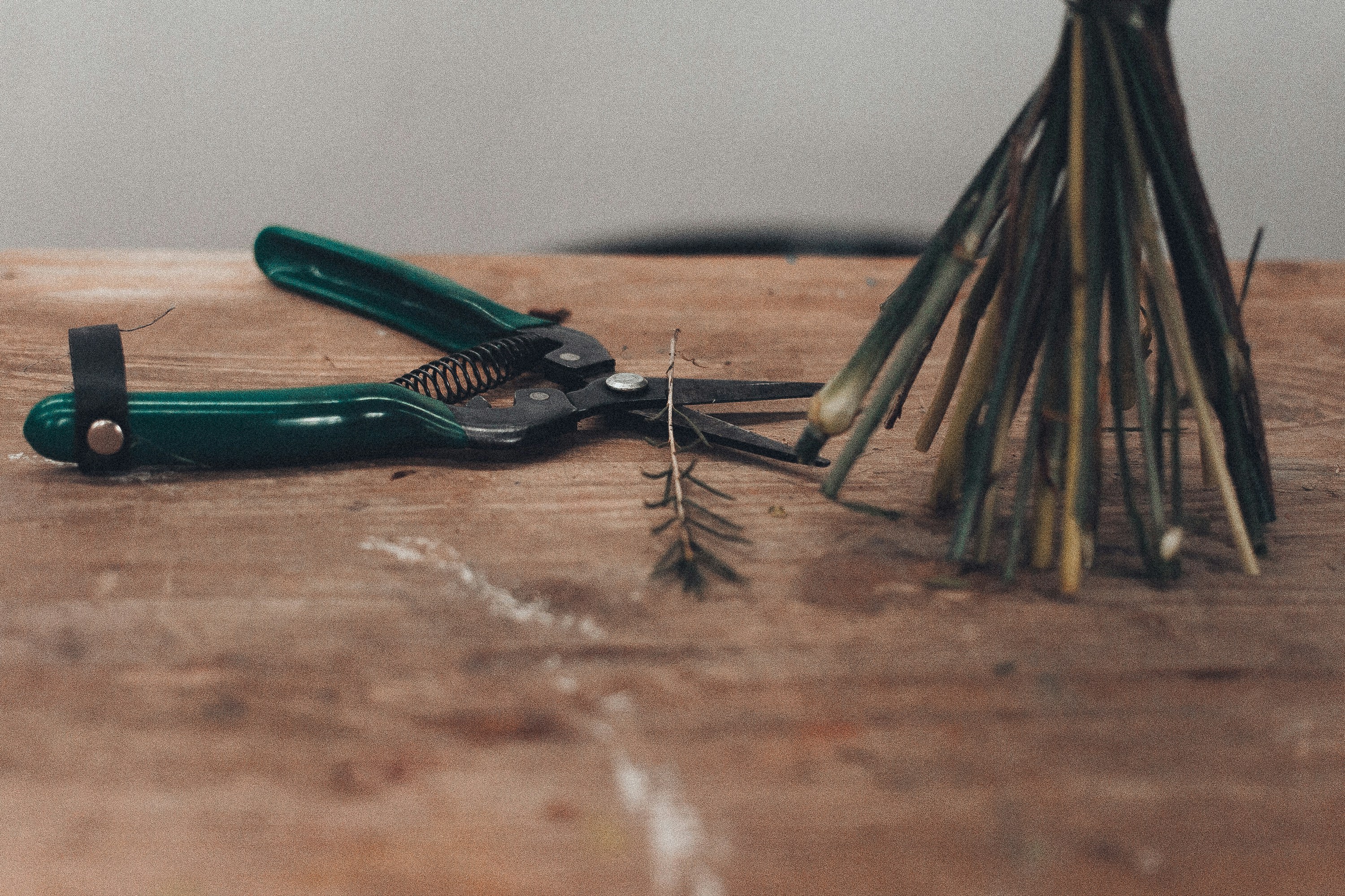 green and black hand tool on brown surface