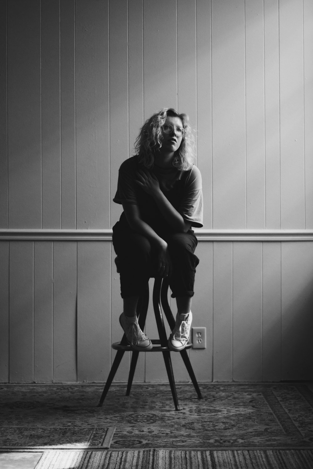 grayscale photography of woman sitting on chair