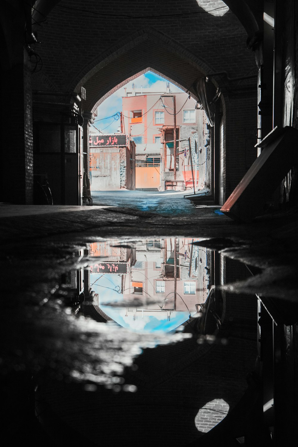 a reflection of a building in a puddle of water