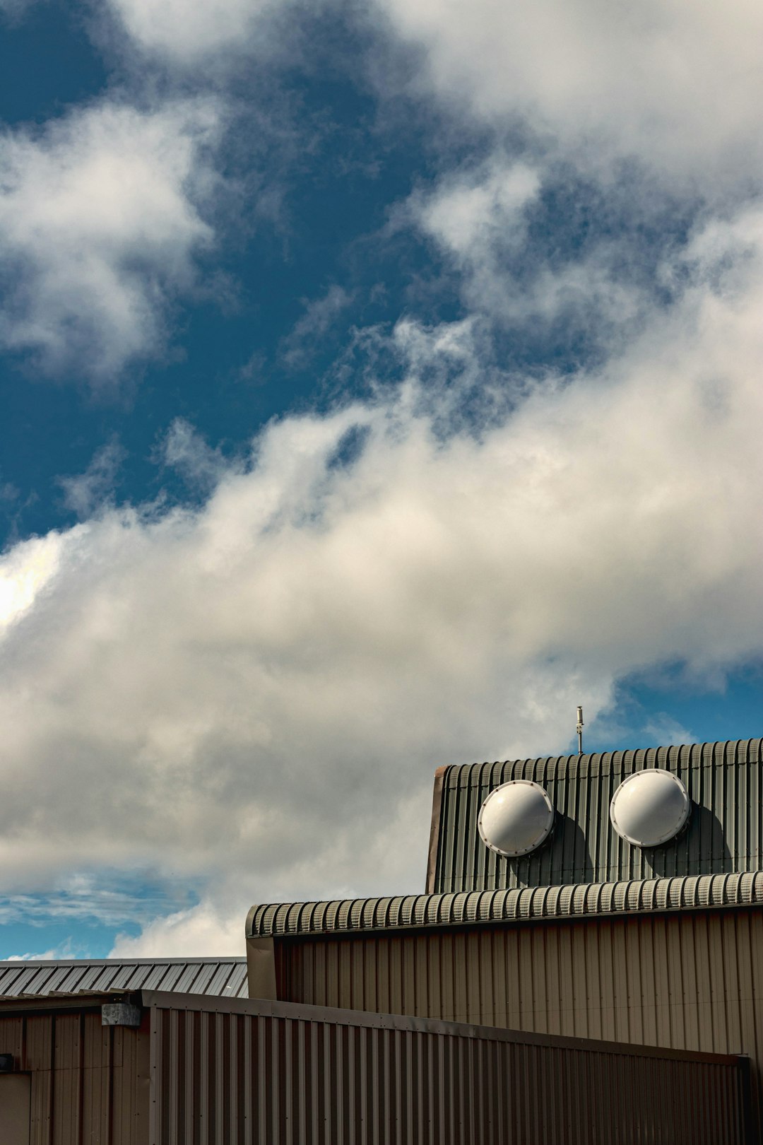 brown building and white clouds