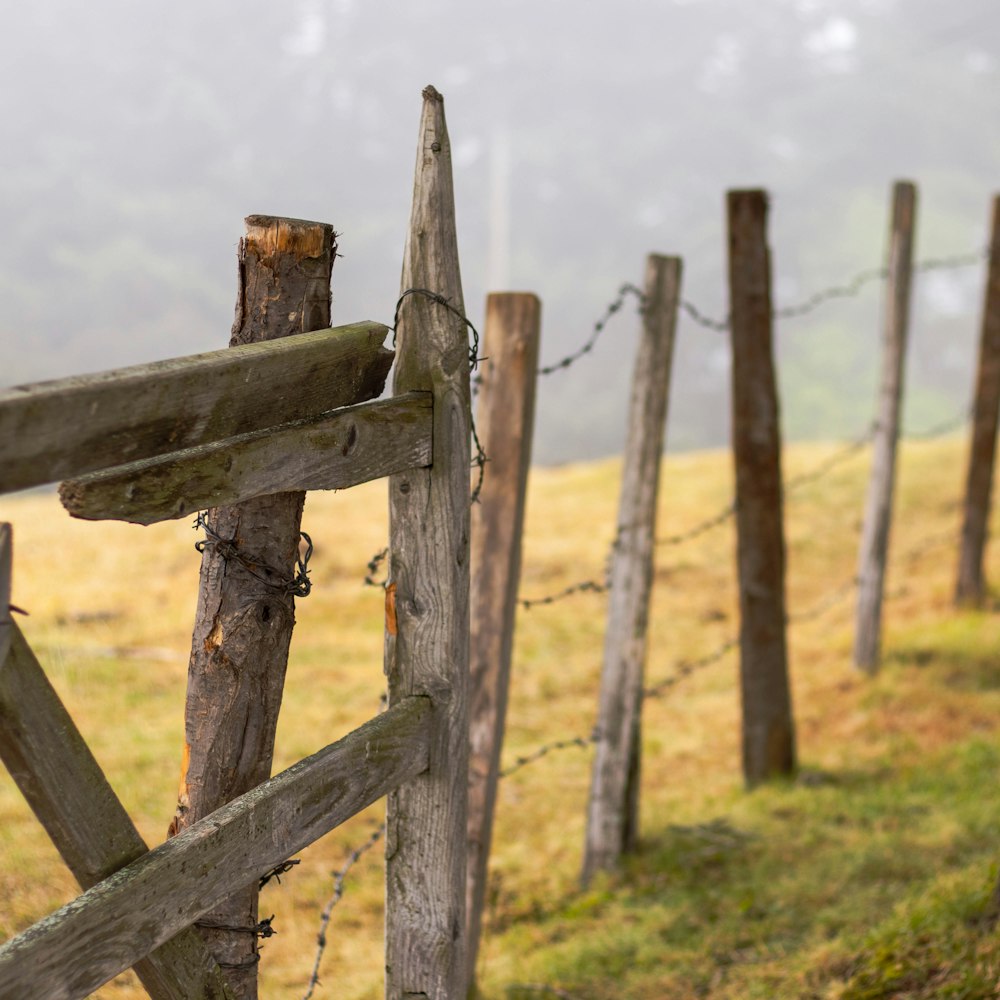 photo of brown wooden fence on grass field