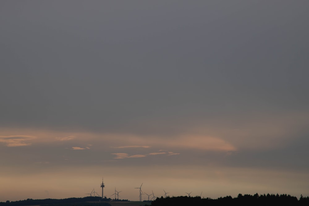 Silhouette von Windmühlen unter bewölktem Himmel