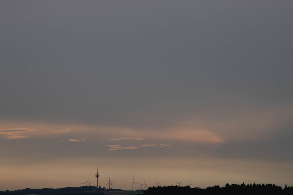 silhouette of windmills under cloudy sky